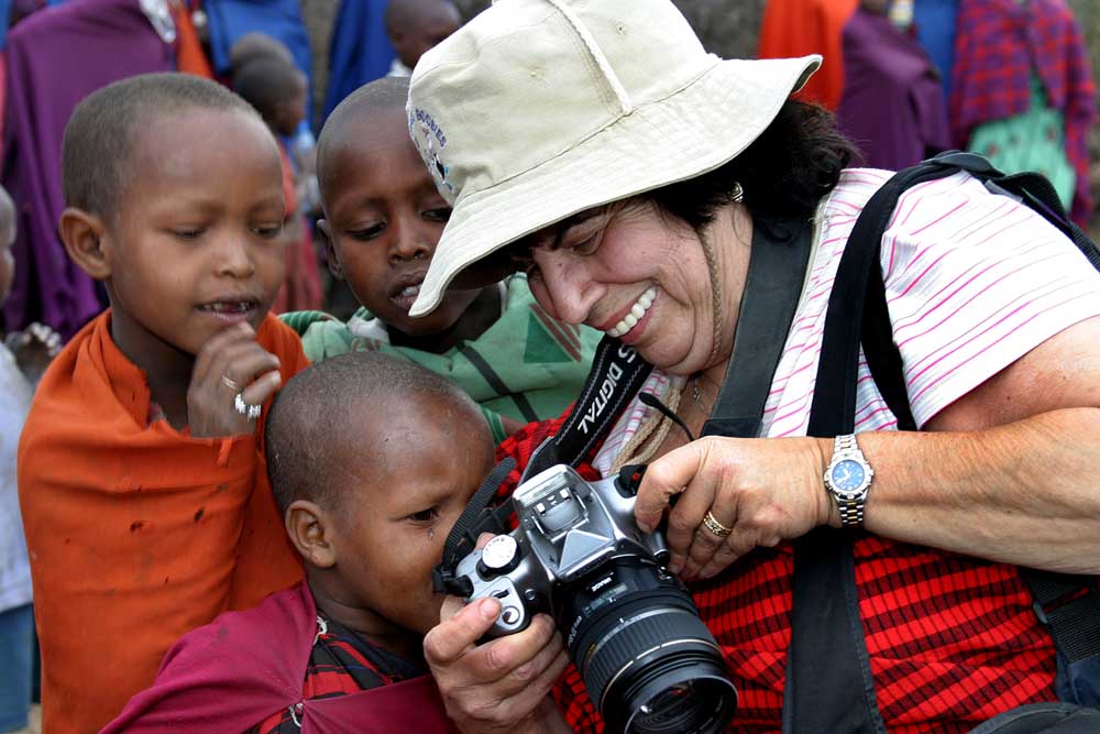 Carole showing kids their photo Tanzania